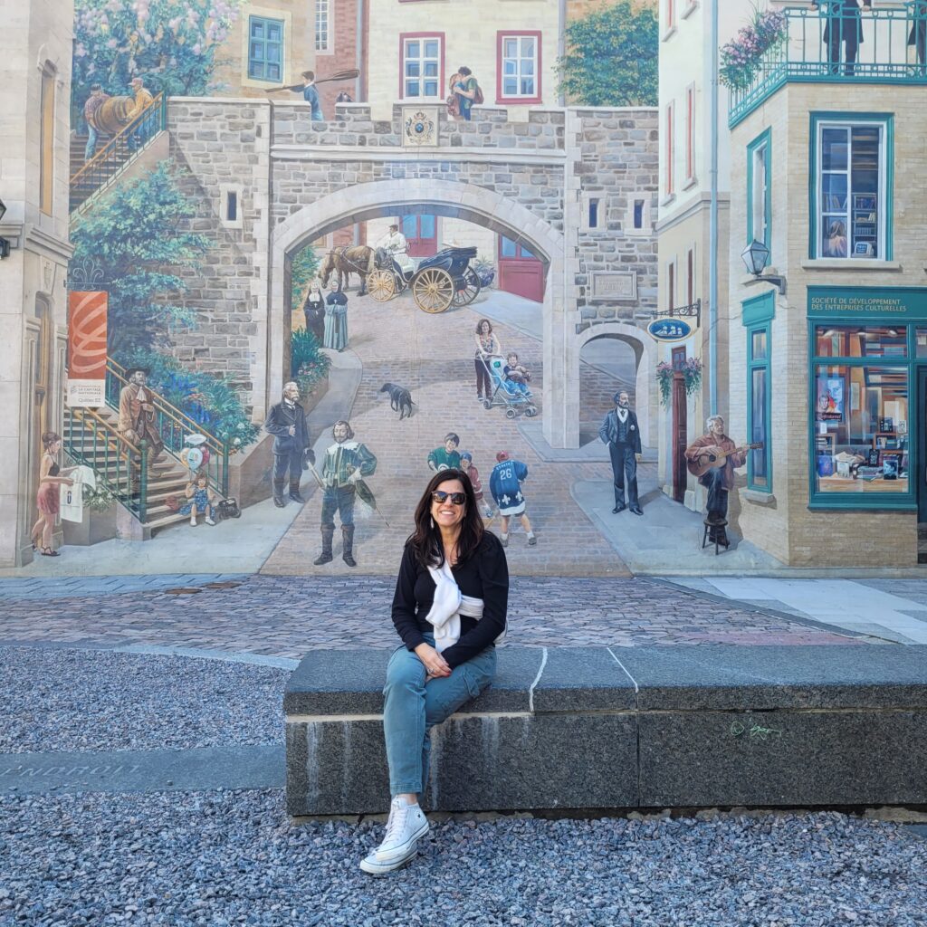 Rose em frente ao Mural da Cidade de Quebec.